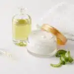 closeup shot of organic oil and cream, dropper, towel and aloe vera slices